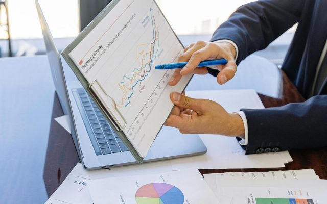 Business professionals discussing financial graphs and charts in an office setting.